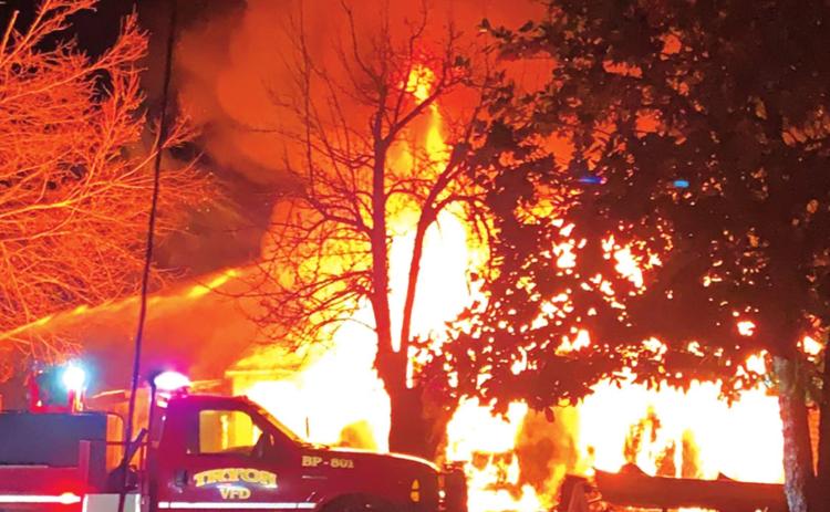Firefighters battle a blaze in Tryon that involved two houses and an out building Monday.