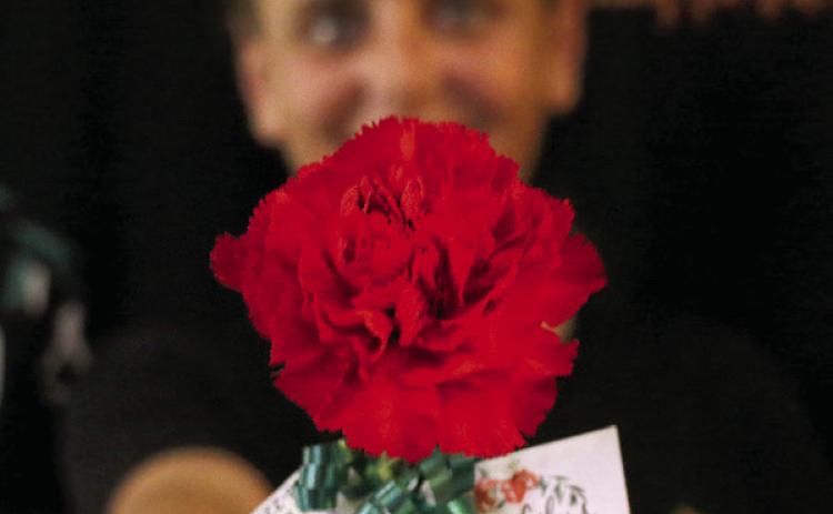 Tiger Lily’s Floral Designs owner Jenifer Hixson shows off a “Petal it Forward” carnation ahead of the Petal it Forward event Oct. 14. Photo by Allie Prater.