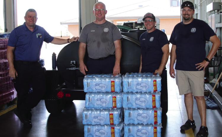 Cushing Emergency Management Director Franklin Reed, Cushing Fire Captain Justin Mincer, Cushing Fire Corporal Justin Ward, and Cushing Fire Chief Dalton Novotny stand in the fire station-turned water distribution center last week. Photo by Allie Prater