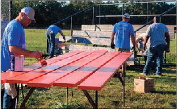 Enbridge employees painting bleachers at Yale Elementary School.