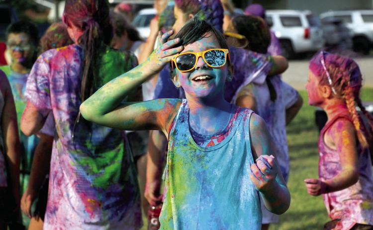 Julz O’Kelley brushes the hair off her prismatic face after the “color explosion” at the 2024 Do or Dye color run hosted by the Geographic Club of Cushing Saturday, Aug. 17. Photo by Allie Prater. See page 6 for more color run photos.