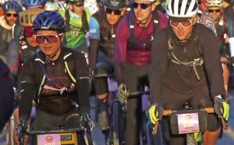 Laiken and Chris Holzer, of Perkins, make their way through the start line crowd at the start of the 100 mile Mid-South Gravel race Saturday, March 16. Photo by Allie Prater.