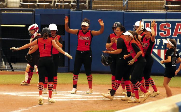 The Cushing Lady Tiger softball team celebrates as they greet freshman Matti Terrell at the plate after she blasted a solo home run over the centerfield fence of the stadium field at Devon Park, formerly known as the USA Softball Hall of Fame in Oklahoma City Friday. The Lady Tigers went on to defeat the Locust Grove Lady Pirates 11-3. The Lady Tigers are sitting on an 8-1 record and are ranked as the No. 8 team in Class 5A. See story Page 5. Photo by Rebecca Withiam.