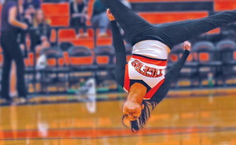 Lindy Candler performs a tumbling pass during the Tiger Dance Team’s performance at halftime of the boys game against Mannford. See story inside. Photo by J.D. Meisner.