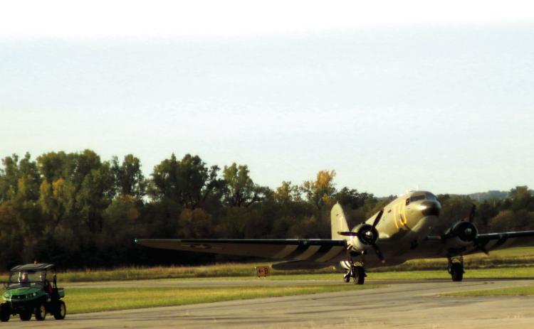 Airport Manager Mike Middleton leads a C-47 to to the tarmac at the Cushing Municipal Airport during the Fly-in and Fun Fair held last fall. Photo by J. D. Meisner