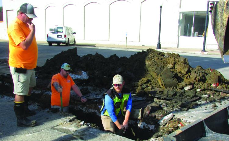 City crew members Daniel Burt and Justin Mosher dig in the dirt to replace a waterline on South Harrison Avenue from Cherry Street to Broadway while Billy Hickman supervises and Steven James works construction equipment to clear away debris last Wednesday on Sept. 4. Burt said there would be further work due to future street and sidewalk renewals that are planned. Photo by DeAnna Maddox