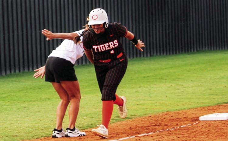Ava Hepensberger gets a little love from head coach Nikki York as she rounds third after crushing a homer over the left field fence. Photo by Dallas Lauderdale