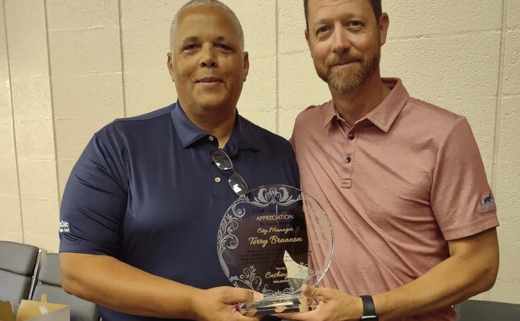 Left: Left: Freshly retired city manager Terry Brannon stands with interim city manager Derek Griffith during Brannon’s retirement party Friday, June 28.