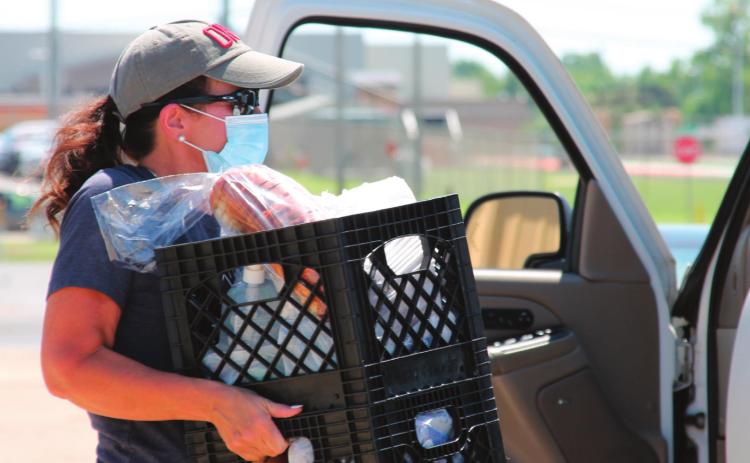Shelly Wilson works hard carrying crates filled with groceries out to one of the participants during the Our Daily Bread event on Aug. 25 at the Cushing Community Food Pantry.