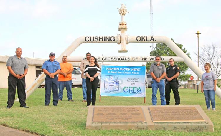City of Cushing employees pose with the “Heroes Work Here” banner, presented by the Grand River Dam Authority. GRDA and City of Cushing have been public power partners since 1953. Pictured, back row from left, Terry Brannon, Firefighter Josh Leach, Shaun McDowell, Brent Youngman, Tina Graves, Glen Cates, Officer Cody Carpenter and Nicole Beeler.