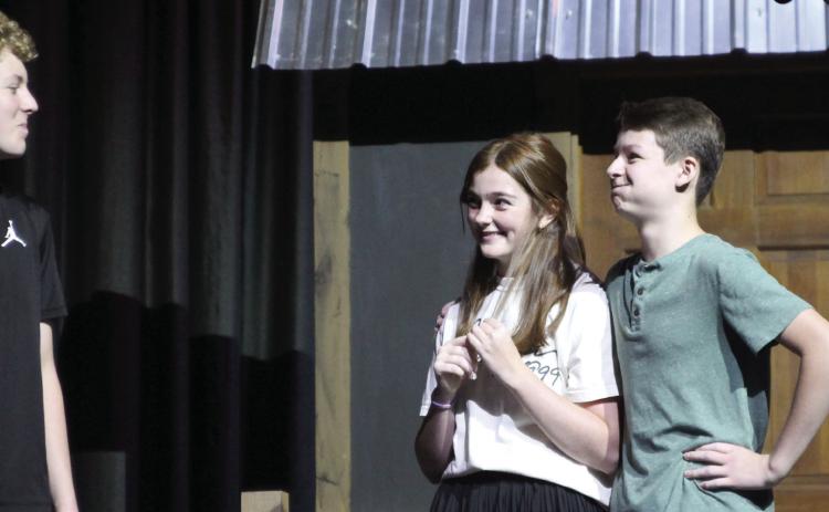 Harper Beasley as Tevye, Evi Bussell as Tzeitel, and Kyzer Gaither as Motel rehearse a scene of “Fiddler on the Roof Jr.” during the Cushing Theatre Camp on July 17. After being directed that “he was supposed to be in love” by Kristin Tarp, Gaither hurriedly placed his arm around Bussell and held back a laugh.