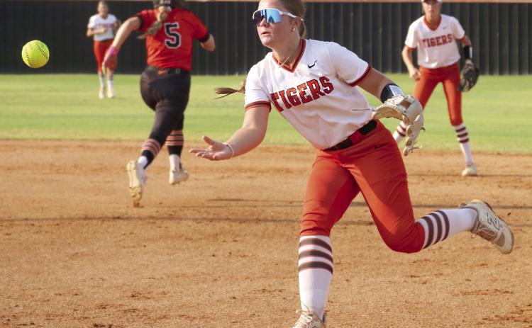 Freshman Lady Tiger Gracie Morphew throws to first to attempt to get an out on a Davenport Lady Bulldog during the Lady Tiger’s season opener Monday, Aug. 10. Photo by Allie Prater.