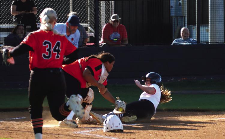 Lady Tiger courtesy runner Zoie Ledgerwood shows no fear as she slides (almost) into home Thursday. Photo by J. D. Meisner