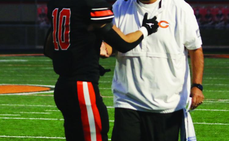 Offensive Coordinator Scott Chisholm congratulates wide receiver Brock Bales after he scored Cushing’s first touchdown of the night Friday.