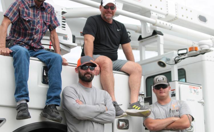 Dub Hargrove and his son Joe, and Doug Biswell and his son Taegan work together at the City of Cushing’s Electric Distribution Department. Photo by J. D. Meisner