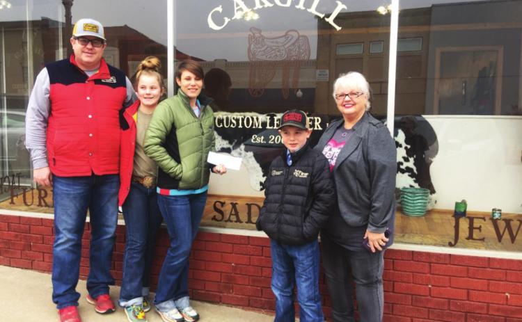 Pictured with the new sign on the windows of their new shop are Justin and Brooke Cargill with their daughter Mercedes and son Beau. At right is DCRA Treasurer Beth Dutton.