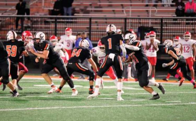 Blaze Berlowitz hands offthe Haden Fry during the Tigers 21-6 win over the John Marshall Bears. Fry had 34 carries for 250 yards and two touchdowns Thursday.