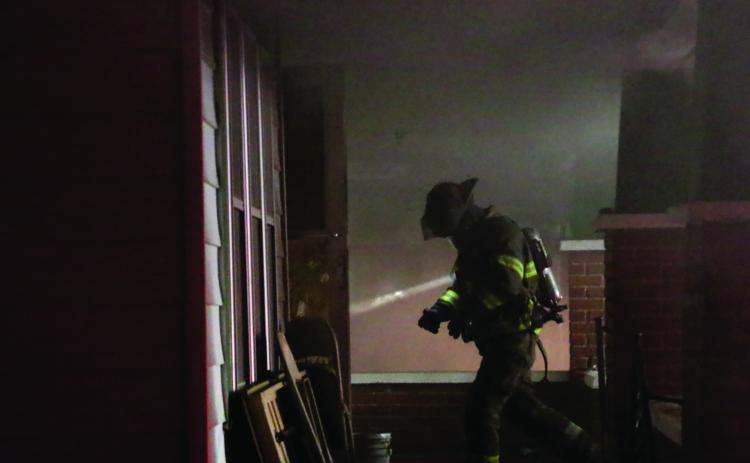 A member of the Cushing Fire Department re-enters the structure.