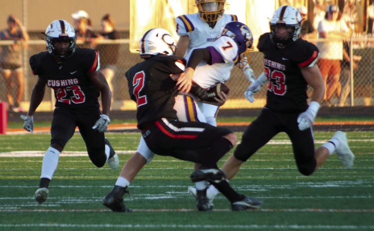 Cushing Tiger Lane Yaunt brings down Bristow ball carrier Jon Montgomery Friday, while Tiger defenders Noah Jones and Riley Matheson look on. The Tigers scuttled the Pirates 63-20 and held Bristow’s offense scoreless until late in the third quarter. Photo by J.D. Meisner