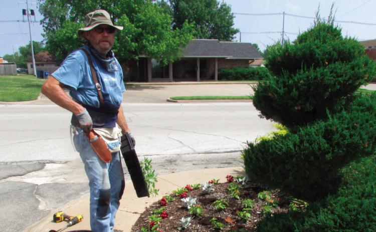 Ben Welch works on the plant beds on the north side of BlueSky Bank. Photo by DeAnna Maddox
