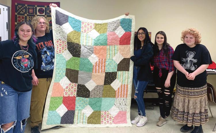 Students of the CHS Fashion and Design class proudly holds a quilt they created. The quilt is the result of a class project and will be donated to Citizens Caring for Children. From left: Chloe Hallabaugh, Jacob Camren, Diana Flores, Jenna Mckinney, and Jasmine Norman.