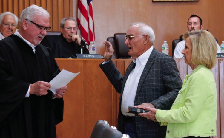Winetta Lamb holds a family bible for her husband Ron as Municipal Judge Bill Ahrberg administers the oath of office to newly elected commissioner Ron Lamb. Photos by J.D. Meisner