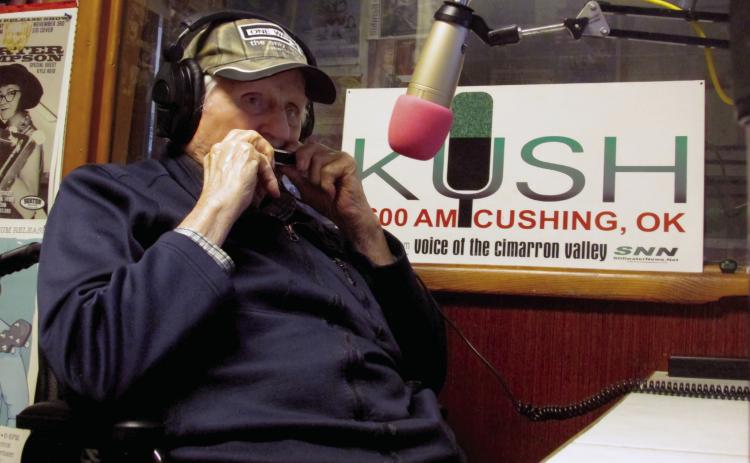 Don Wilbur plays the harmonica in the studio of KUSH Radio. Photo by DeAnna Maddox