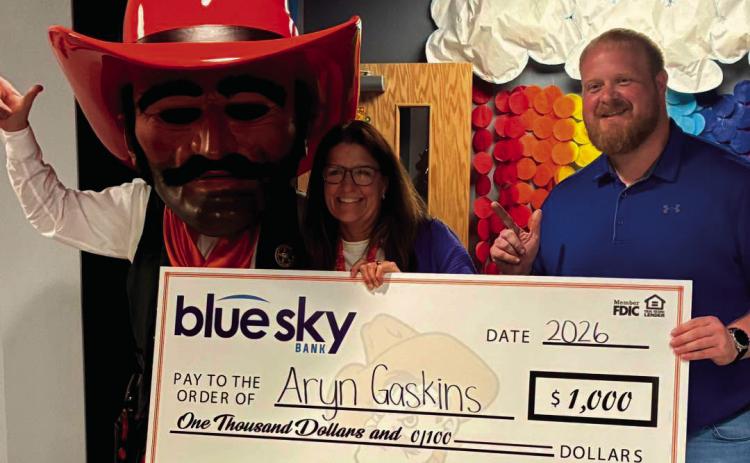 Pistol Pete and Blue Sky Bank Market President of Cushing Brian Porter Jr. present $1,000 check to Teacher of the Game recipient Aryn Gaskins.
