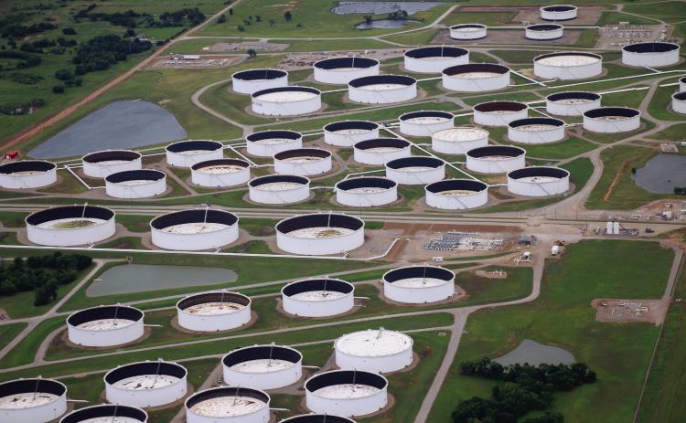 Oil storage tanks at the Cushing hub sit at low capacity. Each tank has a floating lid that rises and falls with the oil inside to prevent product evaporation and buildup of explosive gasses in the headspace. Oil investors and oil market intelligence firms monitor the height of these lids to determine how much oil is in each tank. A lower lid indicates less oil in storage. Photo by Caleson Coon.