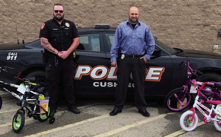 Cushing Police department Officer Wright and Detective Livergood stand with the first four bicycles purchased for the upcoming Bicycle Rodeo.