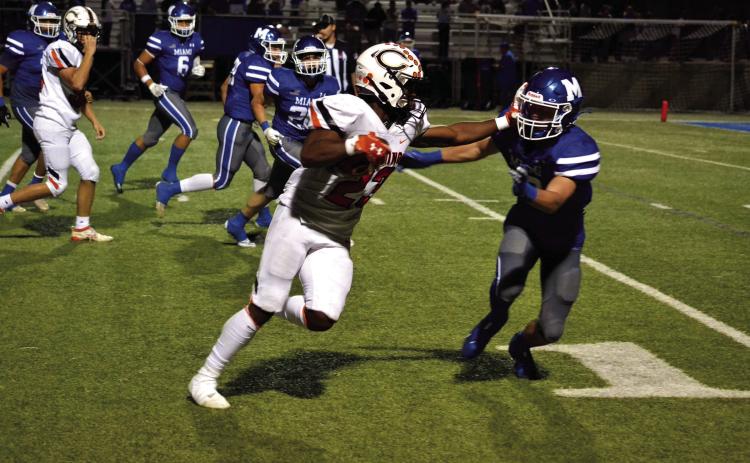 Noah Jones puts the defender in the turf with a stiffarm on his way to the endzone in Cushing's 54-13 win over Miami. Photo by Kaleb Tadpole