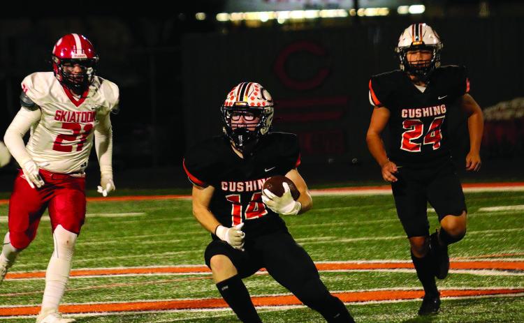 Cushing safety Carl Peterson looks for a seam after intercepting a Skiatook pass Friday in the Tigers’ 61-7 thrashing of the Bulldogs. Backing up Peterson is Cushing freshman linebacker Cody Robinson. Cushing will host Sallisaw this Friday in the opening round of the OSSAA Class 4A state tournament. Photo by J.D. Meisner