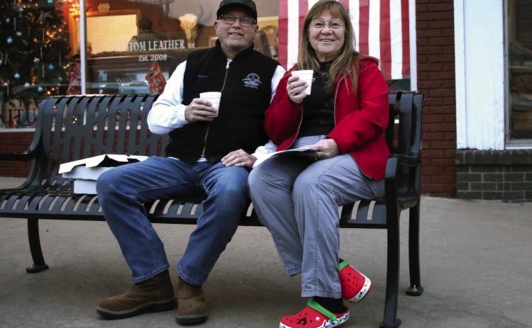 Jim and Shellie Walker enjoy a cup of hot apple cider during the inaugural Downtown Cushing Revitalization Association (DRCA) Cookie Crawl held Tuesday, Dec.12. Seventeen businesses participated in the Cookie Crawl and 92 boxes of cookies were sold. Photo by Allie Prater