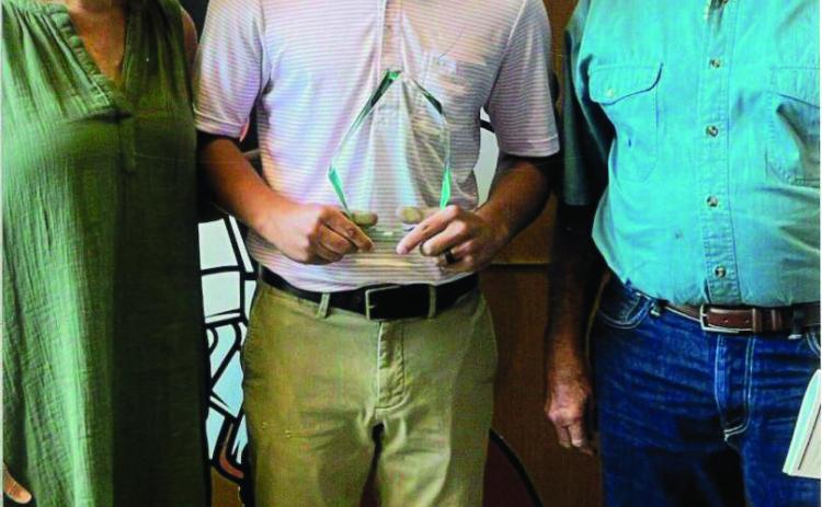 Tricia and Ray McGinnis present Coleton Dallas the Scott A. McGinnis Memorial Scholarship.
